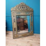 19th C. French brass and ebonised cushion mirror surmounted with cherub and flora and foliage