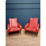 Pair of retro red leather armchairs raised on brass legs{}.