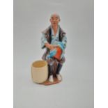 Glazed stoneware Oriental figure of a Fruit Picker. {23 cm H x 14 cm D x 9 cm D}.