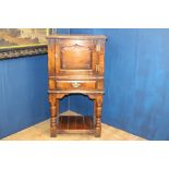 18th C. side cabinet with single blind door above single drawer raised on turned legs and platform