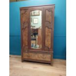 Edwardian walnut wardrobe with mirrored door above one long drawer {200 cm H x 114 cm W x 45 cm D}.