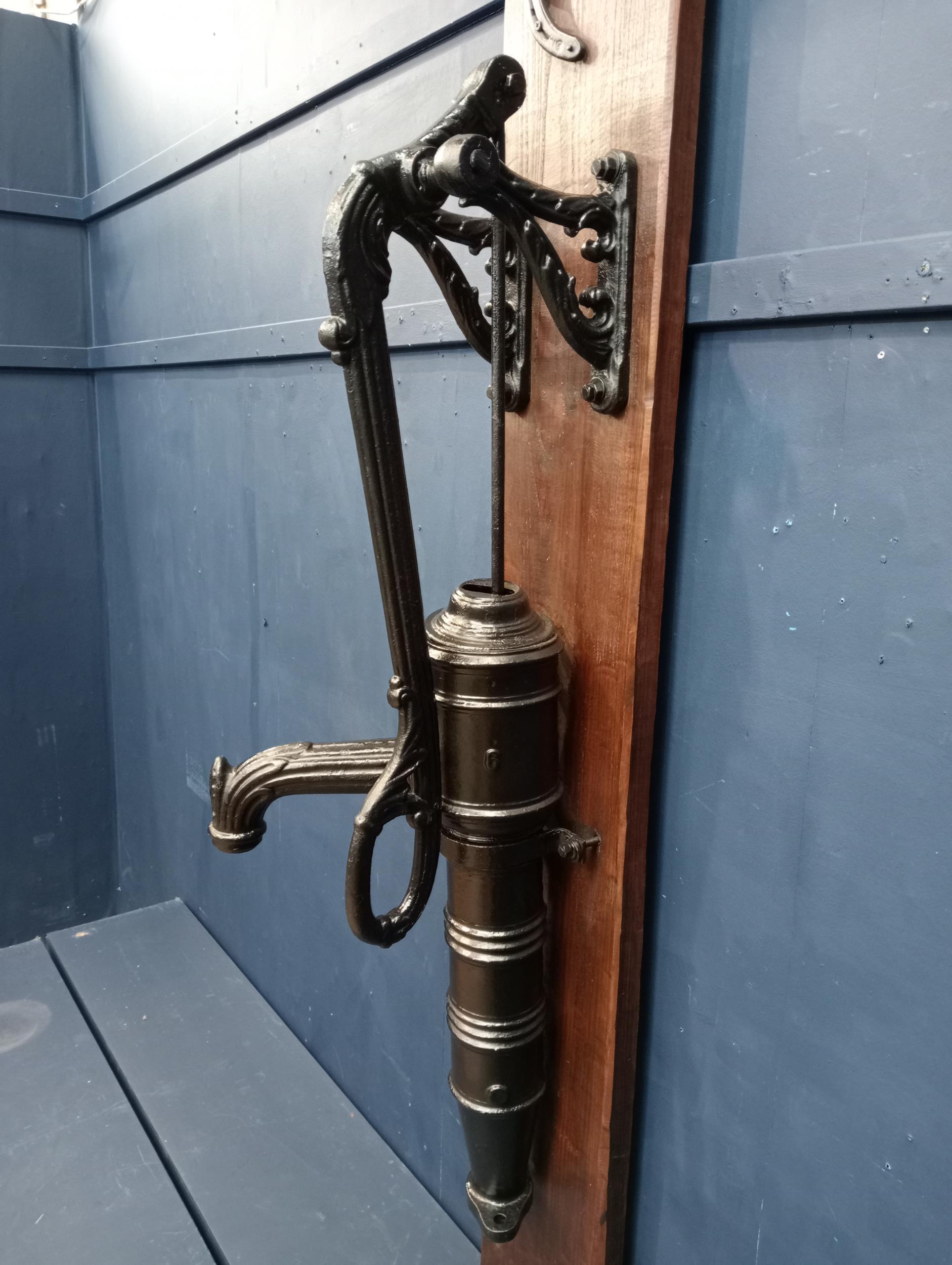 Ornate cast iron water pump mounted on wooden board{H 133cm x W 36cm x D 41cm }. (NOT AVAILABLE TO