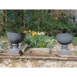 Pair of cast iron urns raised on sandstone pedestal {H 67cm x Dia 60cm }. (NOT AVAILABLE TO VIEW