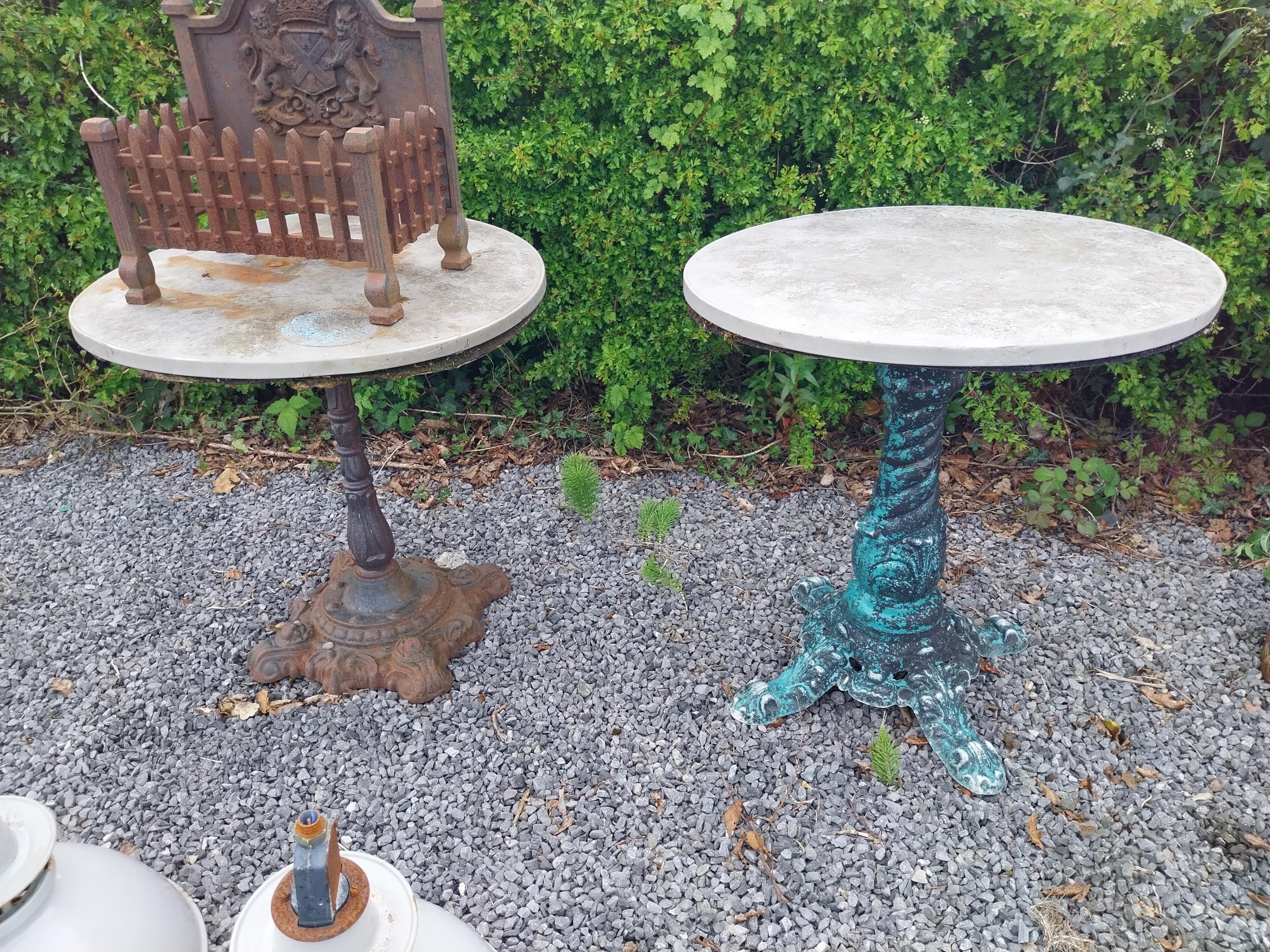 Two cast iron garden tables with zinc tops {74 cm H x 70 cm Dia. and 79 cm H x 70 cm Dia.}.