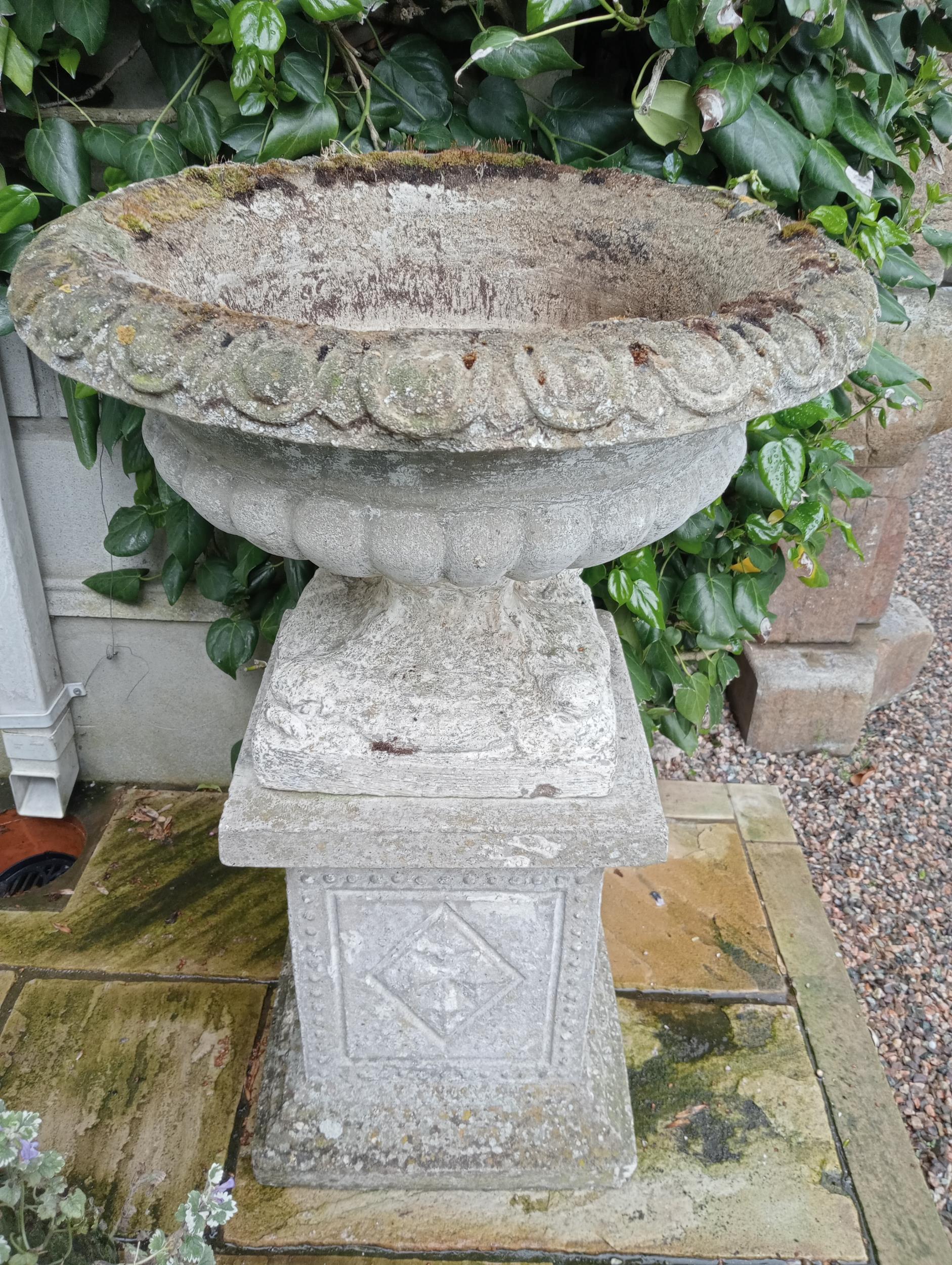 Stone urn raised on plinth {H 85cm x Dia 60cm}. (NOT AVAILABLE TO VIEW IN PERSON)