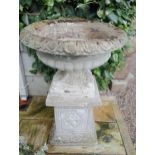 Stone urn raised on plinth {H 85cm x Dia 60cm}. (NOT AVAILABLE TO VIEW IN PERSON)