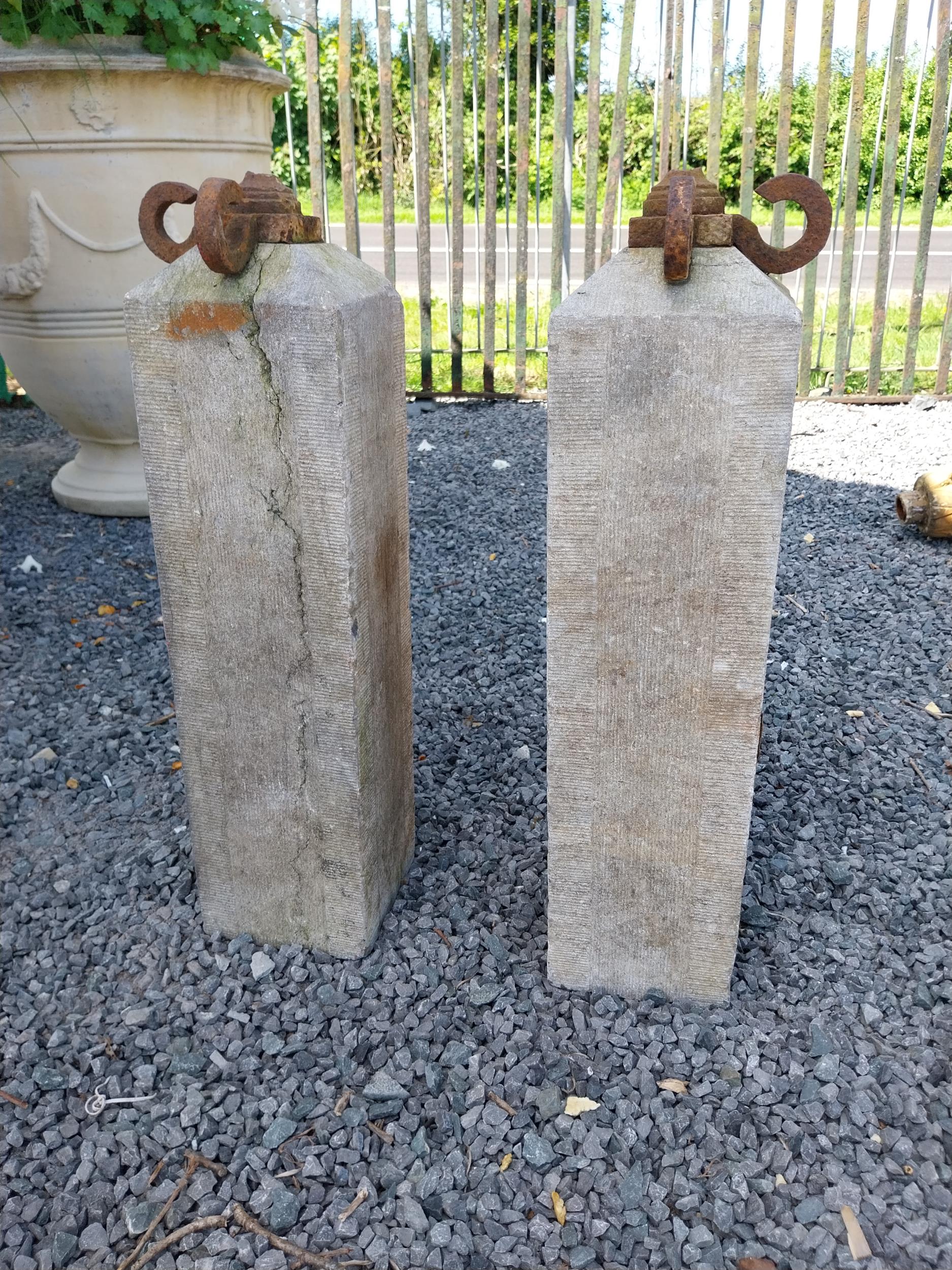 Pair of 19th C. hand-cut limestone bollards with wrought iron tops {72 cm H x 21 cm W x 21 cm D}.