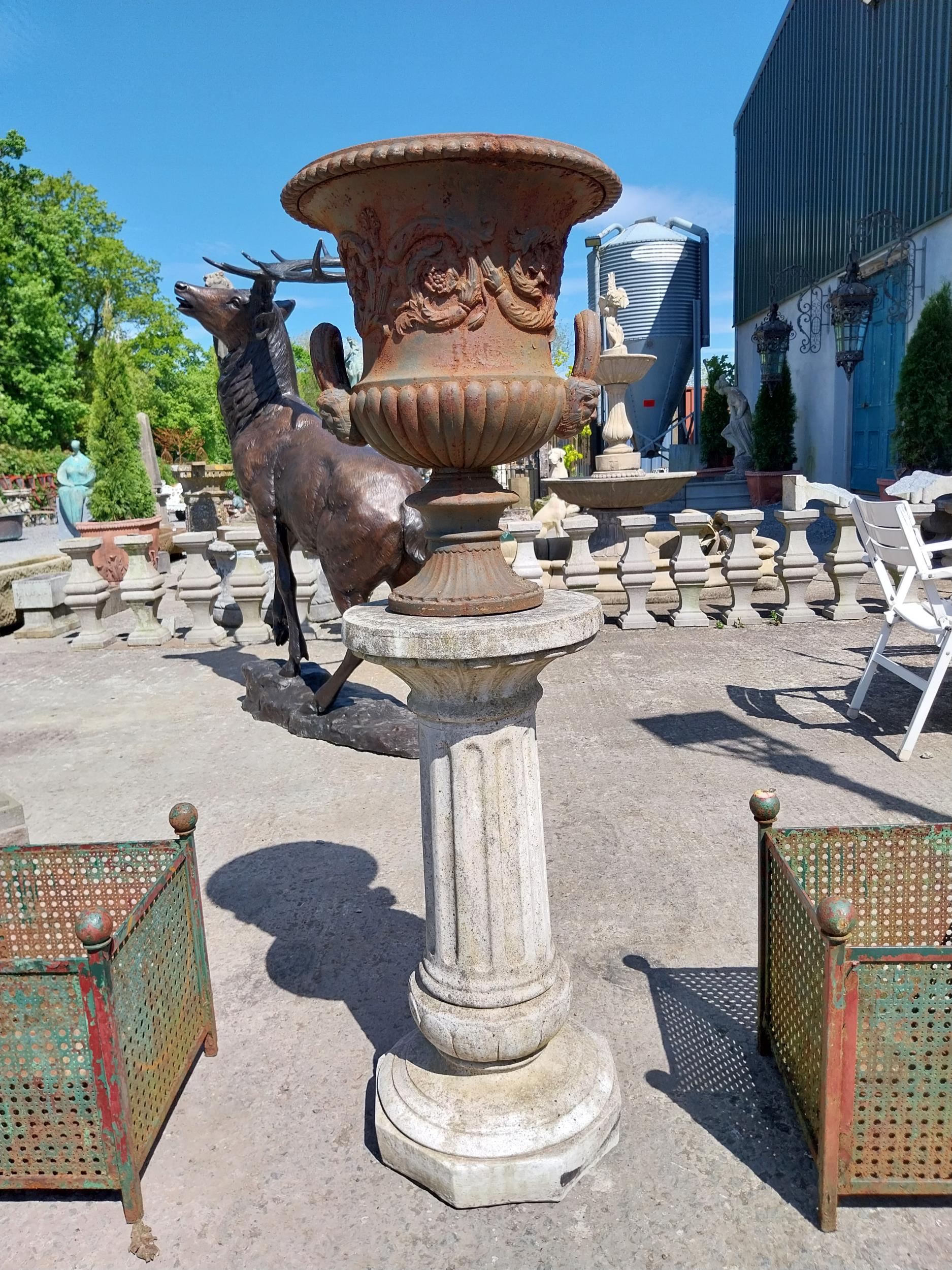 Decorative French cast iron urn raised on moulded stone pedestal {144 cm H x 47 cm Dia.}.