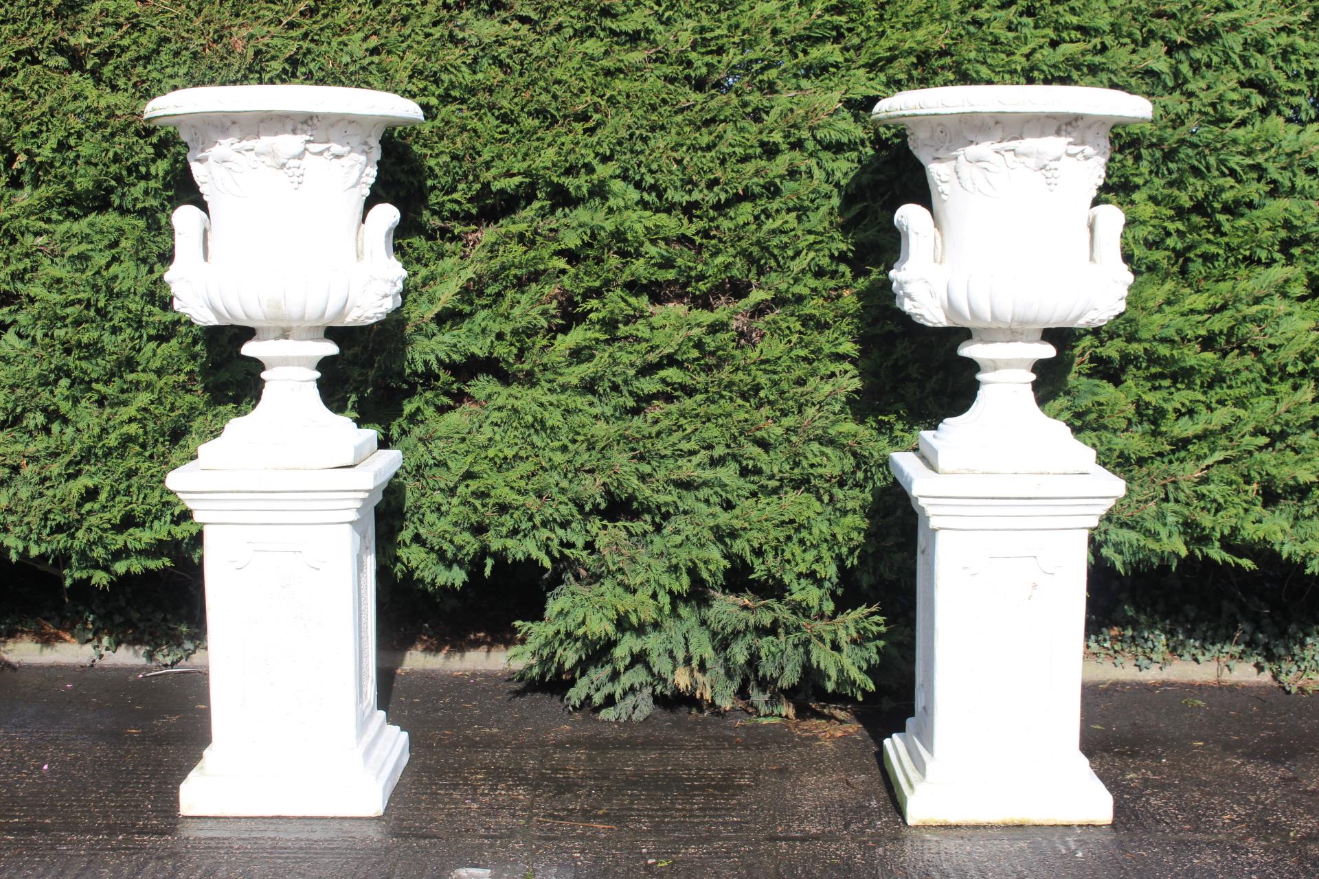 Pair of composition urns raised on pedestals {H183cm x W60cm x D60cm }. (NOT AVAILABLE TO VIEW IN