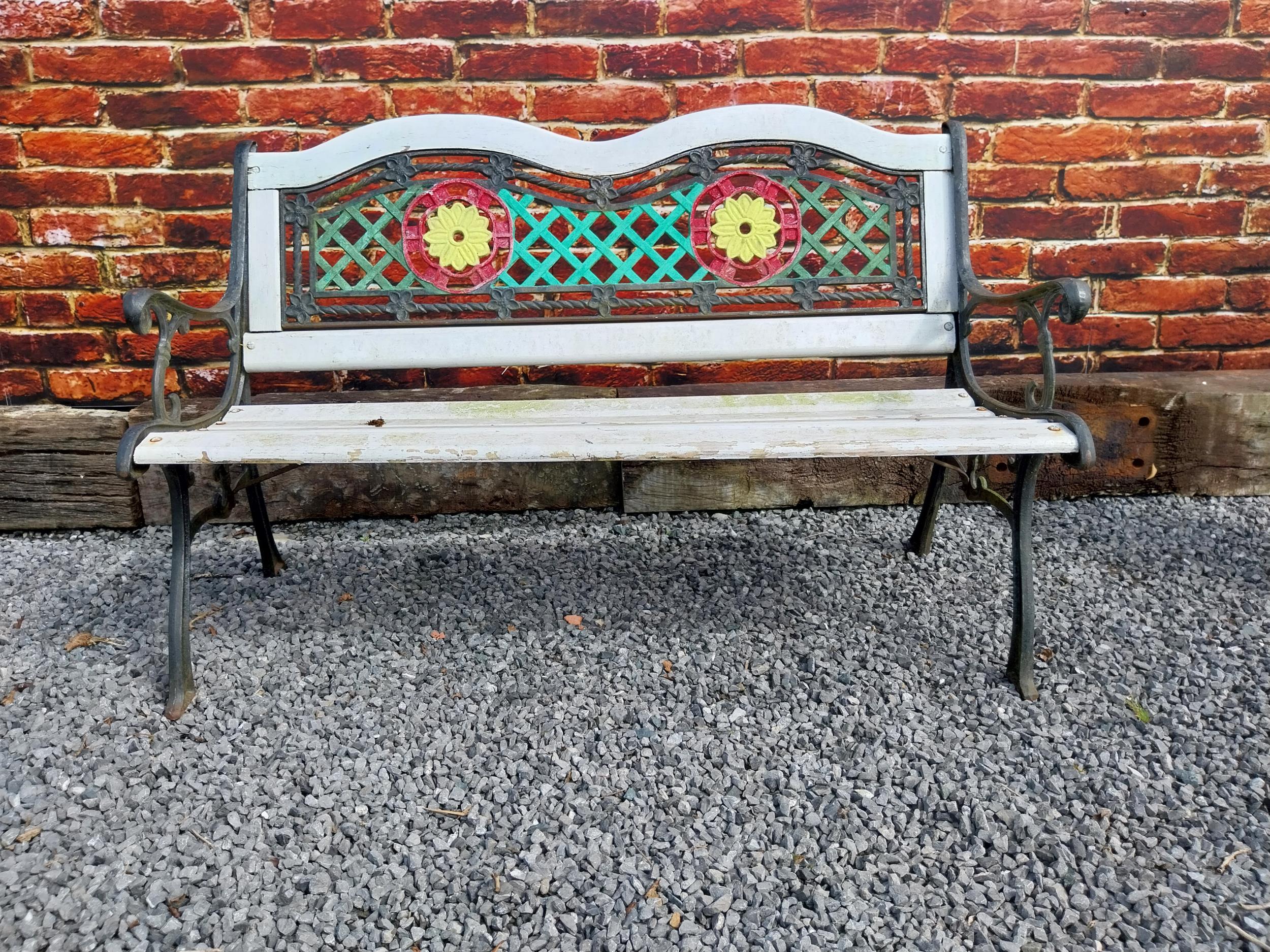 1950s cast iron garden bench with wooden slats decorated with flowers {80 cm H x 128 cm W x 60 cm