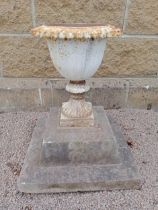 Cast iron urn on stone base {H 50cm x W 43cm x D 43cm }. (NOT AVAILABLE TO VIEW IN PERSON)