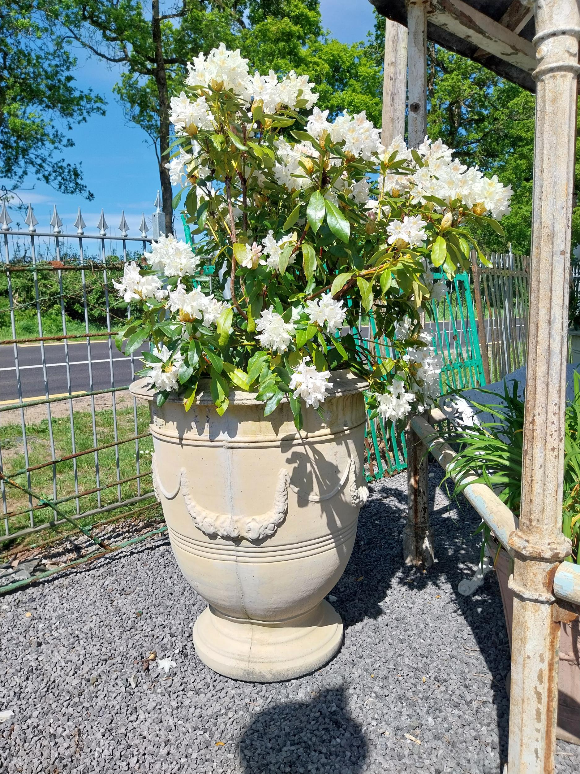 Pair of large moulded sandstone urns decorated with swags including plants {Urns dimensions 100 cm H