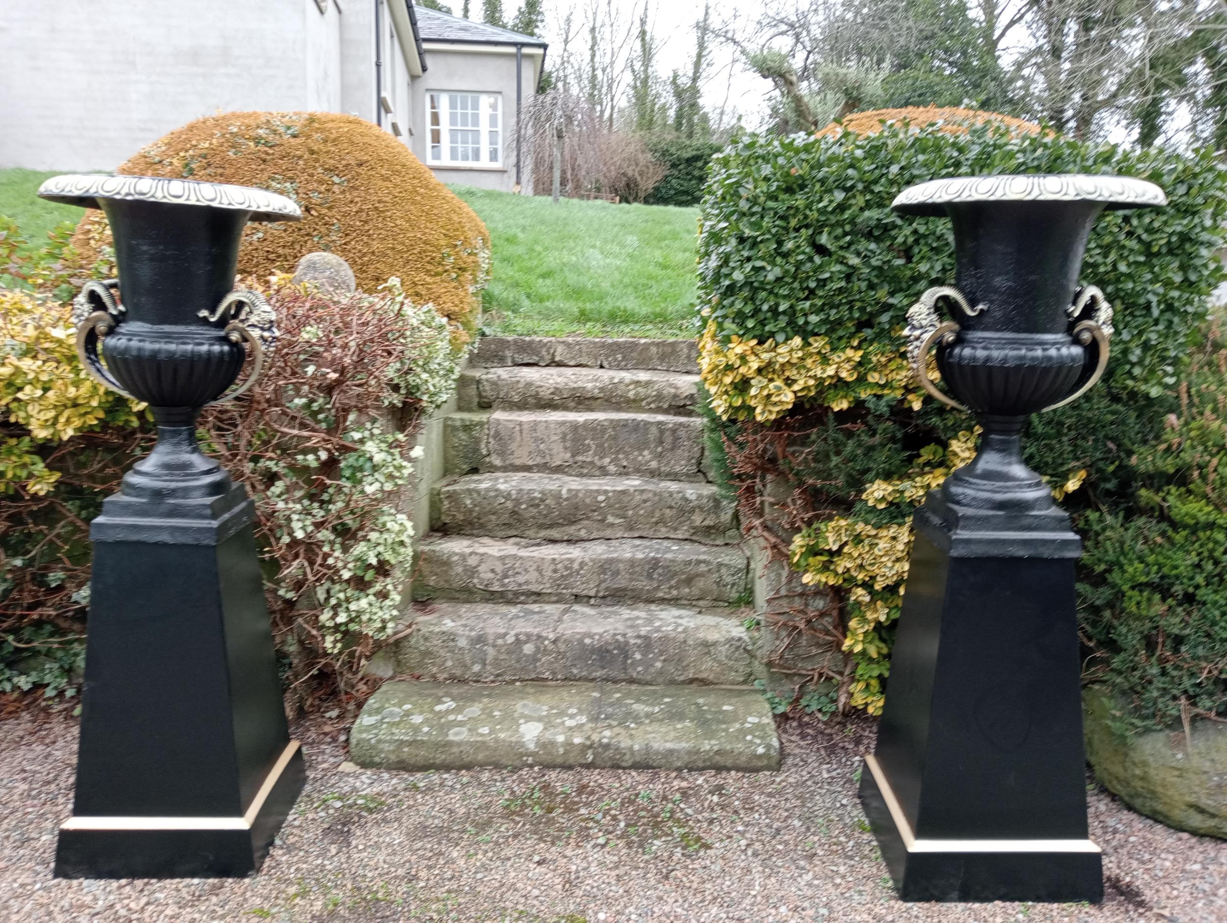 Pair of cast iron urns and bases {H. 185cm x Dia 66cm Base H 93cm x 53 x 53}. (NOT AVAILABLE TO VIEW