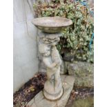 Composition stone fountain depicting cherub holding fish {H 96cm x Dia 36cm }. (NOT AVAILABLE TO