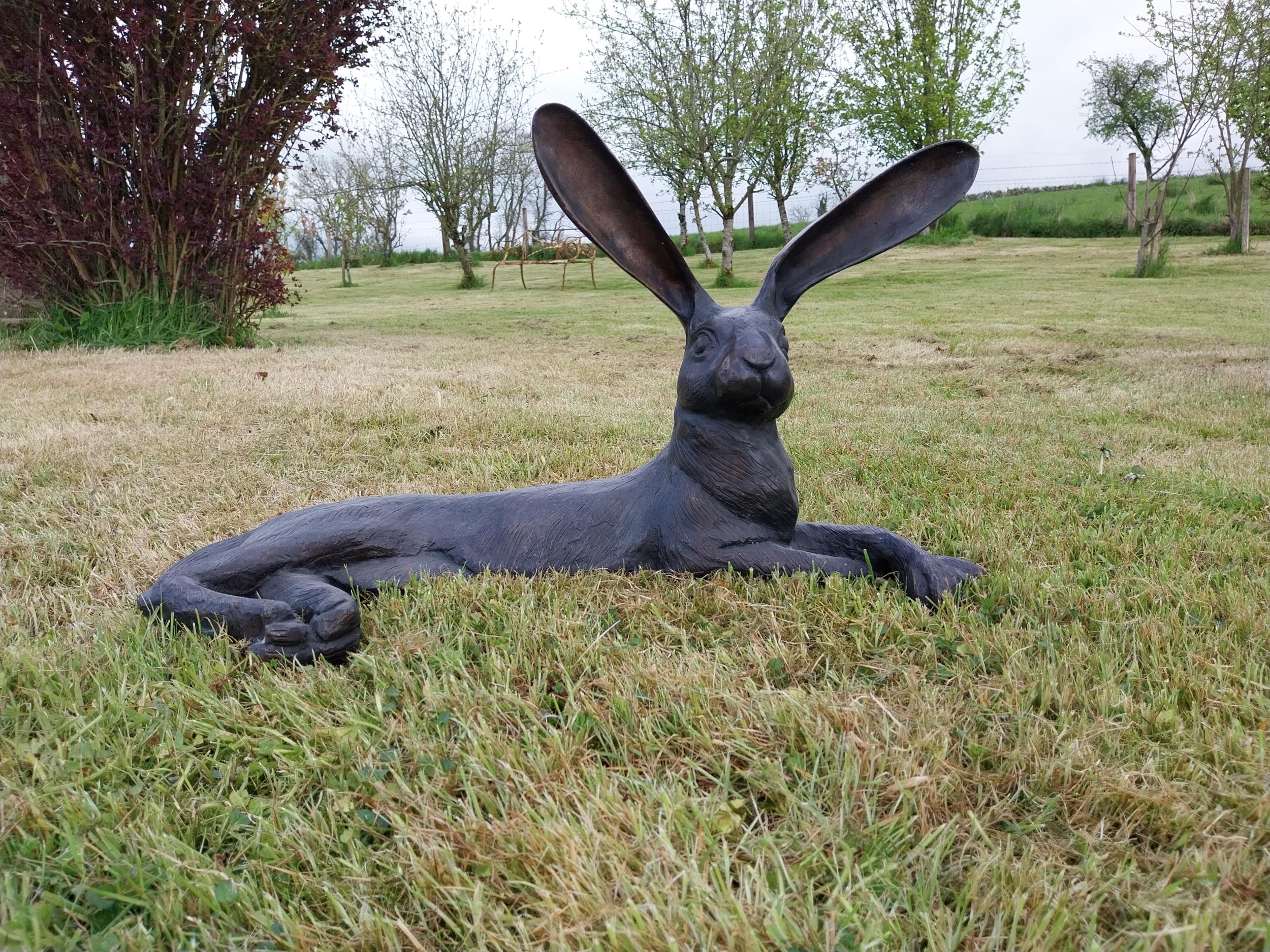 Exceptional quality bronze statue of a lying Hare with ears up {61 cm H x 35 cm W x 20 cm D}.