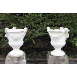 Pair of composite stone urns decorated with swags and tails- bases not included {}. (NOT AVAILABLE