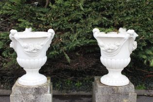 Pair of composite stone urns decorated with swags and tails- bases not included {}. (NOT AVAILABLE