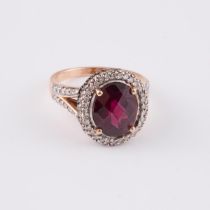 14k Rose, White, And Blackened Gold Ring, set with a fancy oval cut rhodolite garnet (11.1 x 9.0mm),