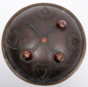 An Indian circular iron shield, dhal, 12" diameter, with 4 applied iron heart shaped panels, brass