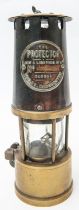 An miner's old brass lamp, "The Protector", by Eccles, Manchester, with heavy brass base and
