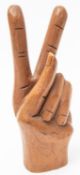 An interesting old "treen" carved hand giving a Churchillian "V for Victory" sign, 8" overall, GC,
