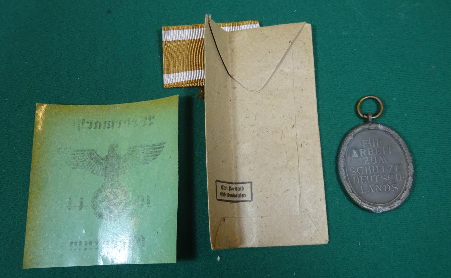 A Third Reich "West Wall" medal, in its printed paper packet with a length of ribbon; an - Bild 2 aus 6