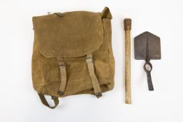 A WWI entrenching tool, dated 1916, with wooden handle; and a webbing large pack from the 1908
