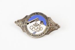 A silvered and enamel pin back badge for the IV Winter Olympics at Garmisch Partenkirchen, 1936,