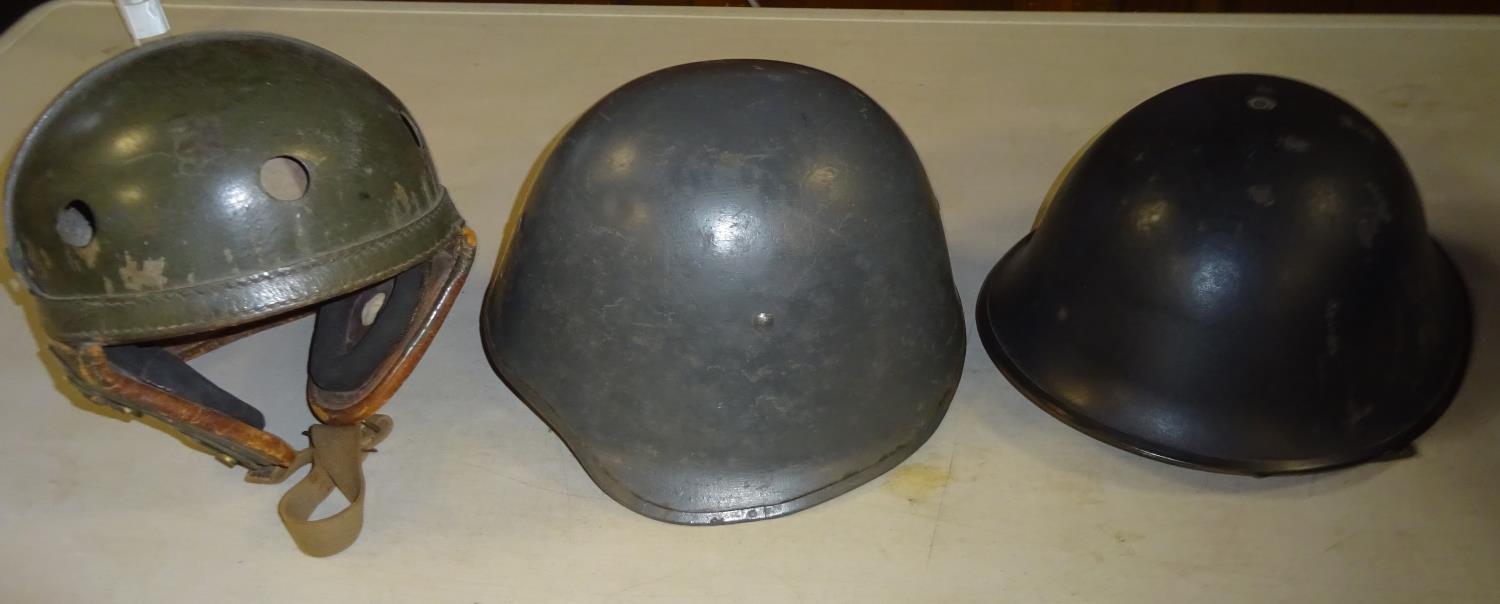 A WWII US Tank crew helmet, olive drab finish worn; A Danish steel helmet and a British 1960s