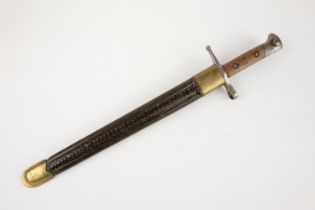 An Italian M1891 Carcano bayonet, in its brass mounted fluted leather scabbard. GC £50-70