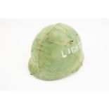 A US Korean War period M1 Helmet, complete with chinstrap and camouflaged cover. GC £50-70