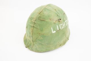 A US Korean War period M1 Helmet, complete with chinstrap and camouflaged cover. GC £50-70