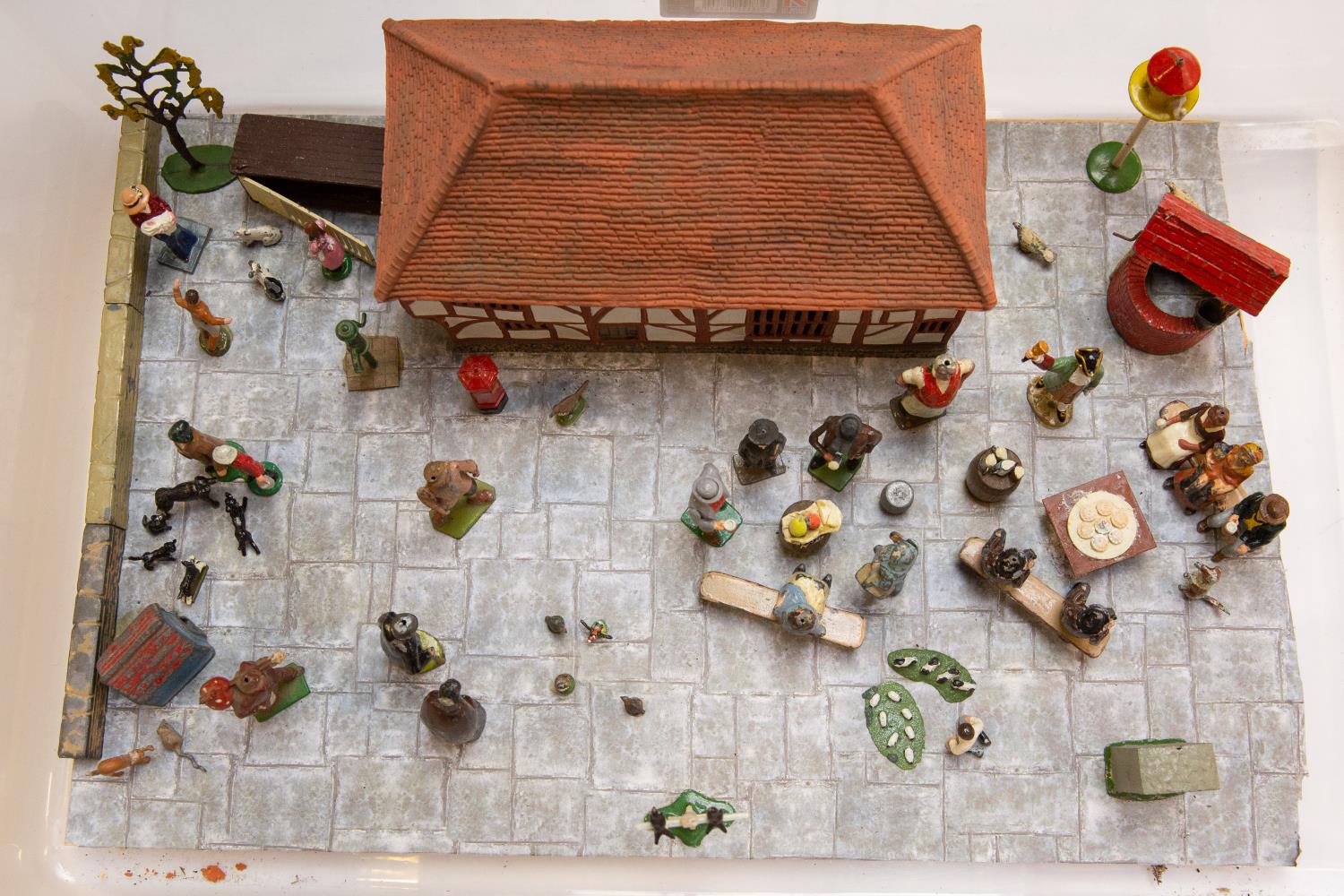 A well made Diorama 'Market Square' using Britains Figures and accessories. Including Village Idiot,