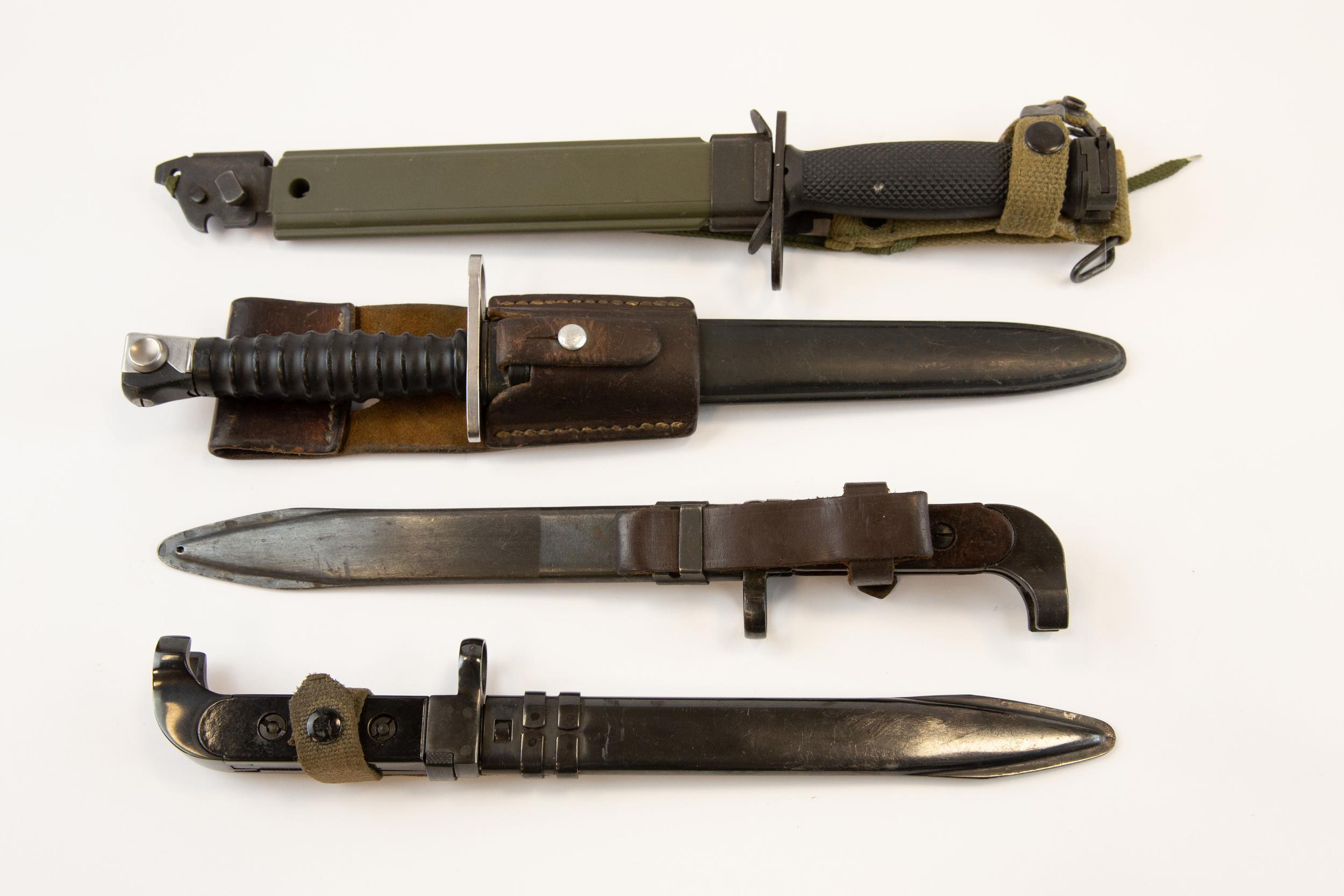 An AK 47 bayonet, with black grips, another with brown grips; a Swiss SG 57 bayonet; an M7 type