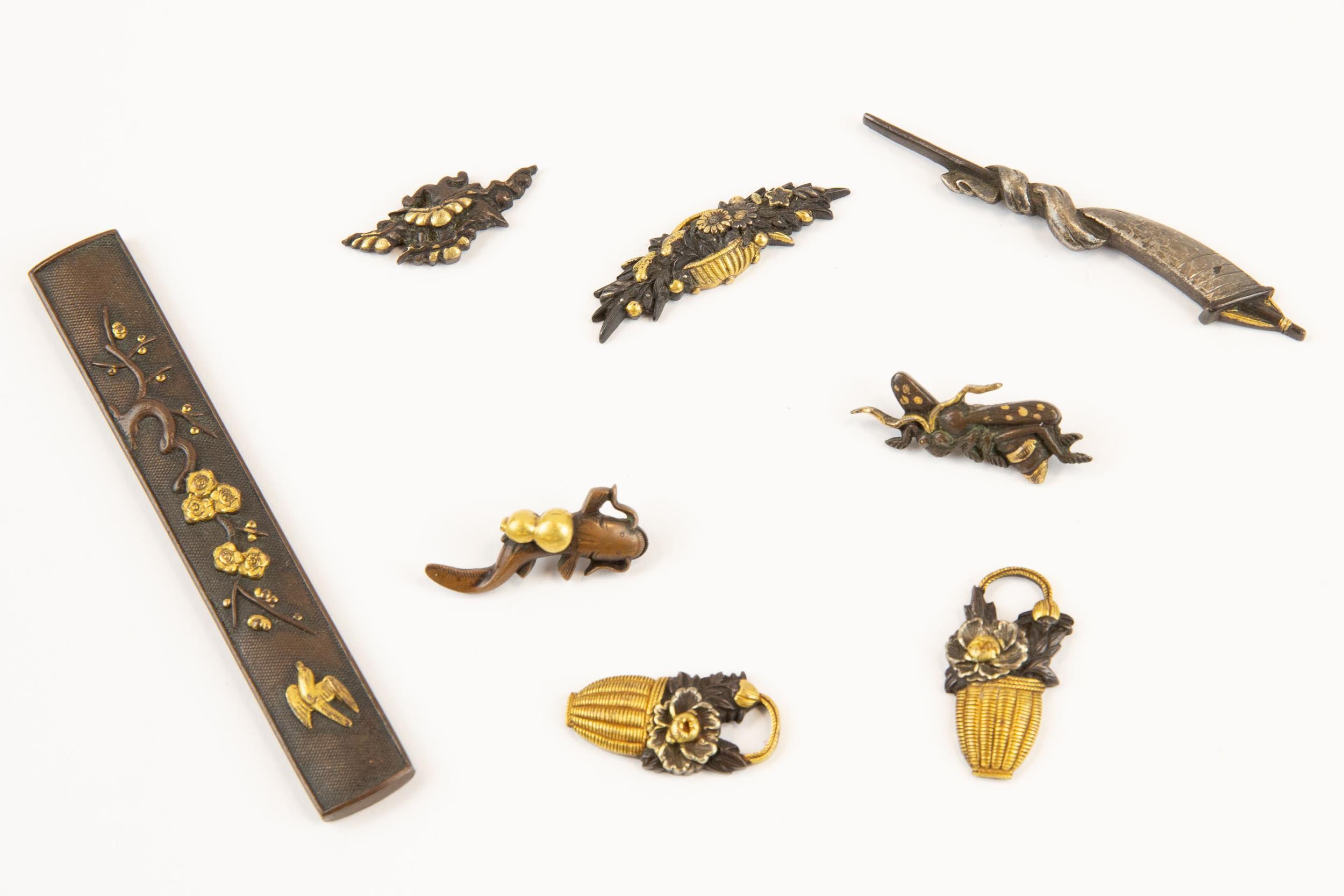 Japanese sword fittings: kodzuka, of shakudo bronze with gold flowers and bird; and seven menuki,