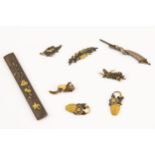 Japanese sword fittings: kodzuka, of shakudo bronze with gold flowers and bird; and seven menuki,