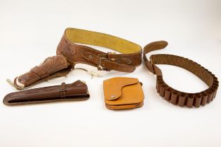 A Mexican tooled leather gun belt and open top holster, decorated overall with foliate scrolls,