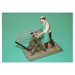 Bing, Made in Germany C.1912 -1914, tin-plate toy of a man sawing a metal bar with a bow saw, This