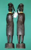 A pair of carved solid ebony tribal woman standing holding containers to there heads. These are from