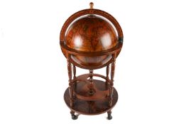 A modern terrestrial globe in the antique style, on a wooden stand decorated with the signs of the