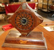 A mantle clock set in a mahogany propeller boss, marked 