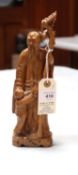 A carved wooden figure of an Oriental gentleman holding a branch, with a small boy below holding
