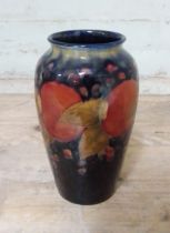 A Moorcroft pottery vase, decorated in pomegranate, height 21cm. Condition - chips to base, loss