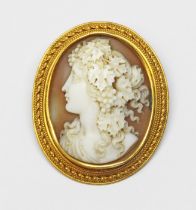 A Victorian shell cameo brooch depicting a classical female head in side profile wearing grape