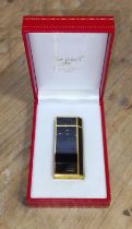 A Must de Cartier Plaque de Laque Noire and gold plated cigarette lighter.