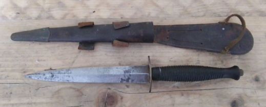 A Fairbairn Sykes commando knife with leather sheath.