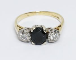 A diamond and sapphire ring, the central dark blue oval cut stone measuring approx. 7.10mm x 5.85mm,