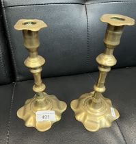 A pair of early 18th century brass 'petal base' candlesticks