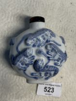 A Chinese porcelain snuff bottle, embossed with foh dogs, tiger's eye top, Guangxu six character