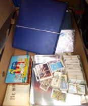 A box including stamp albums, cigarette cards, music and postcards.